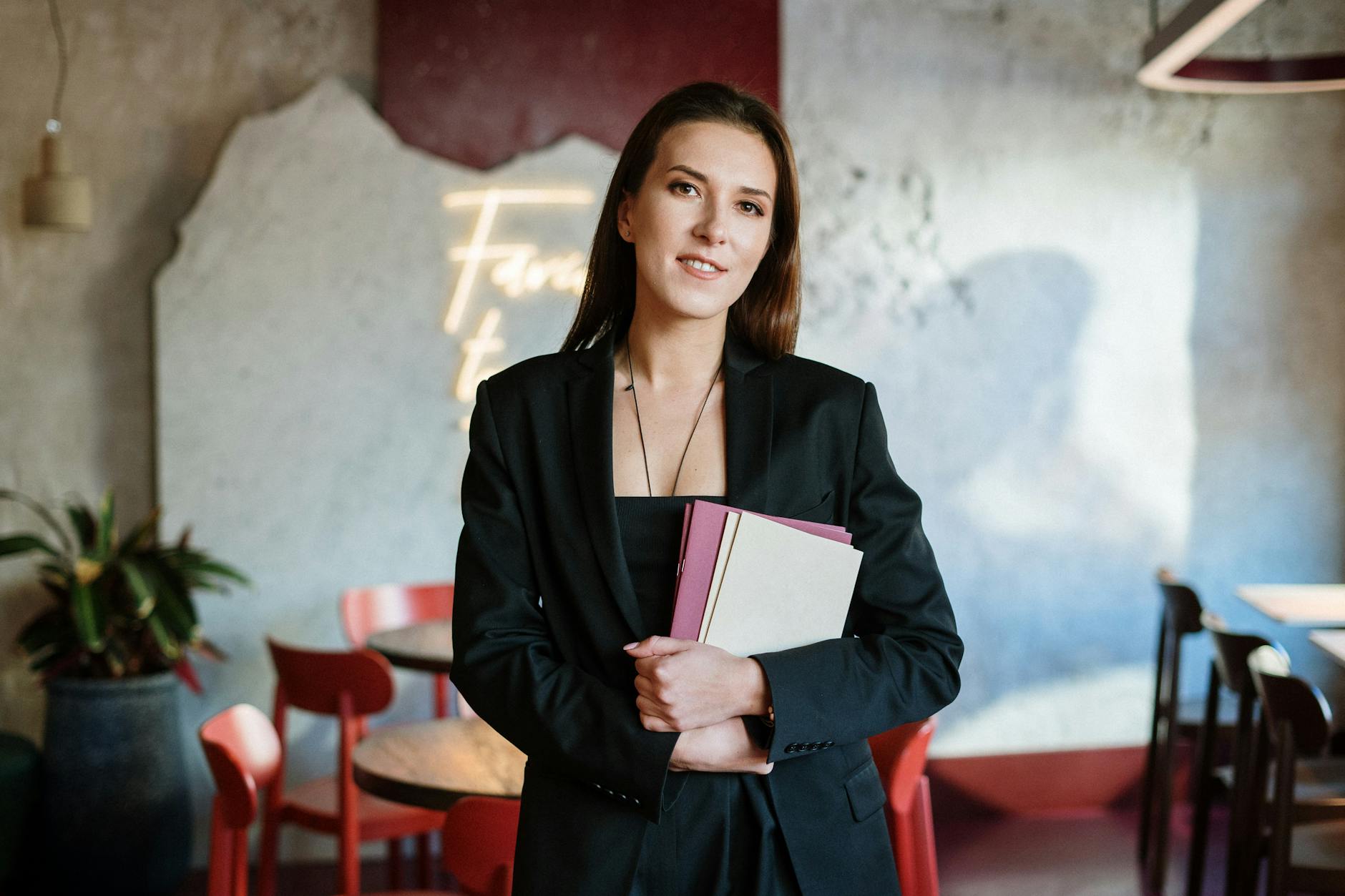 woman in black blazer holding white paper