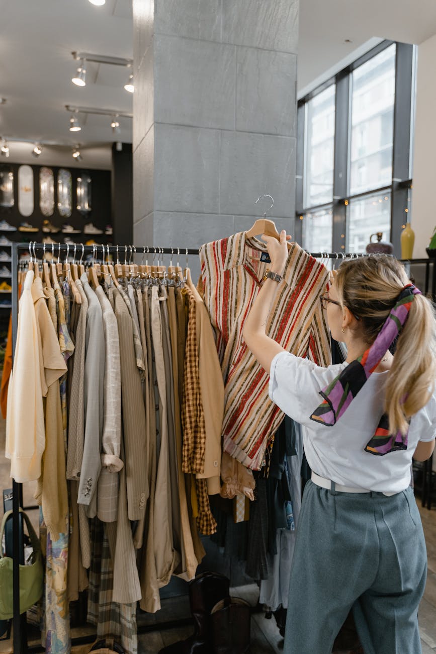 woman in white sleeve shirt standing near clothes rack