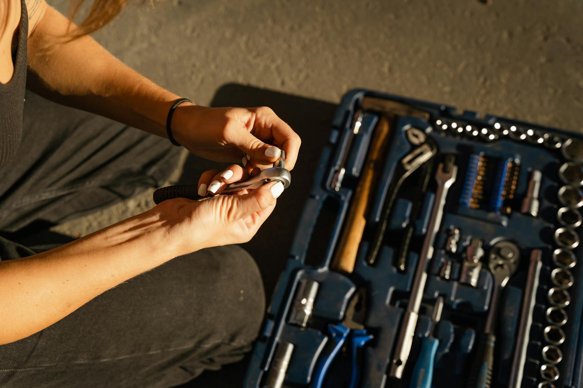 a person holding steel tool and a bolt